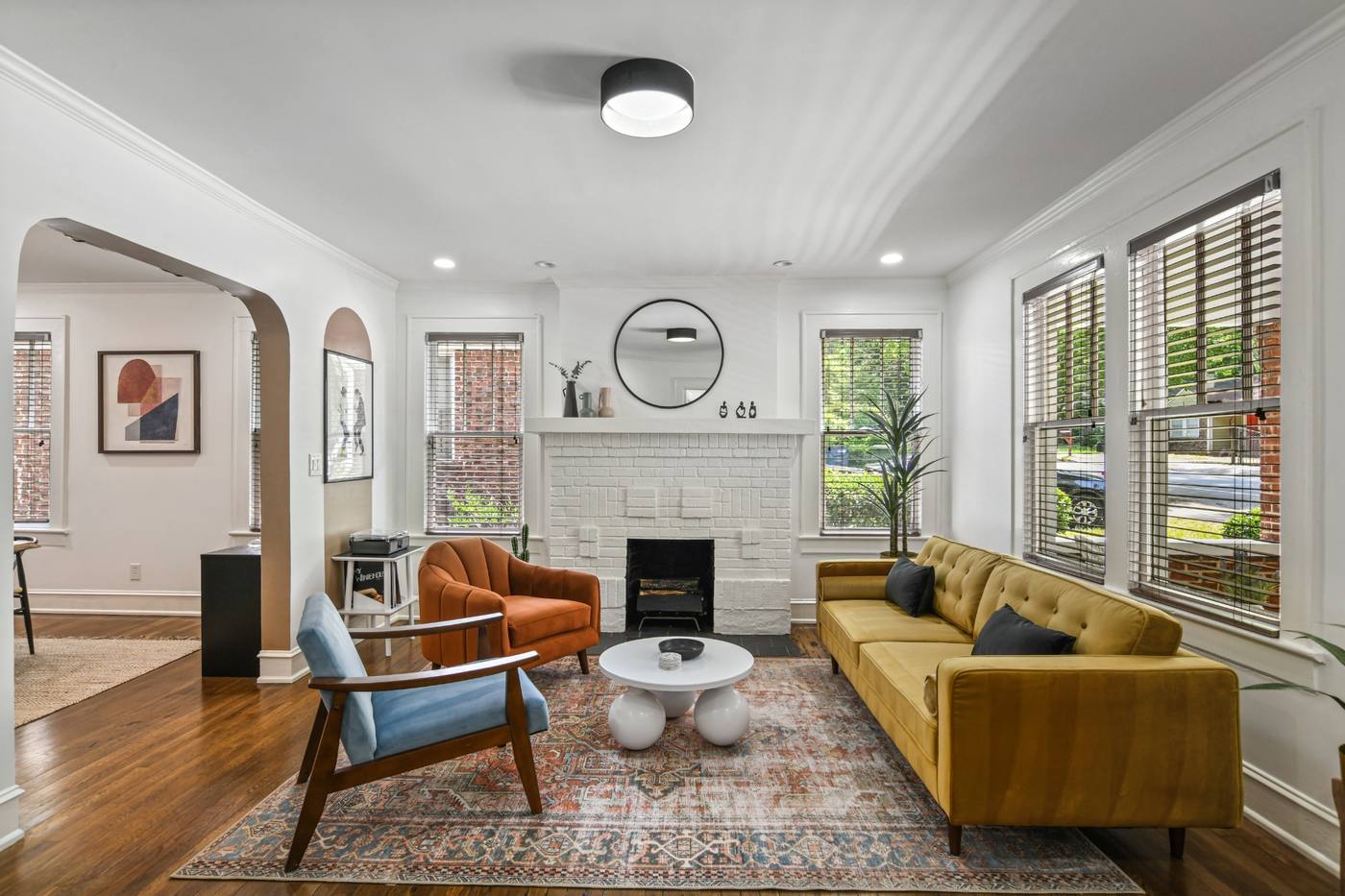 Hosea living room with mustard seating, warm wood, and a central fireplace